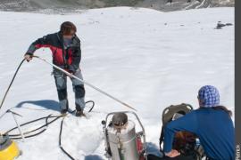 Glaciologues retirant la sonde à vapeur de la glace, avant d'y introduire une balise en bois de 4 segments de 2 mètres.