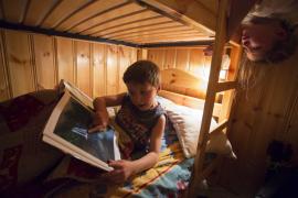 Gite de Chantal et Bernard à Peisey-Nancroix photographié dans le cadre de la marque Esprit parc national, en Vanoise.
Enfant discutant autour d'un livre photo des parc nationaux de France.