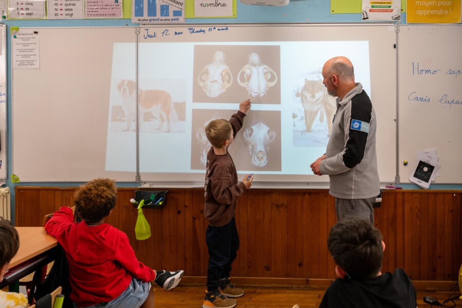 Elève au tableau aux côtés d'un garde-moniteur