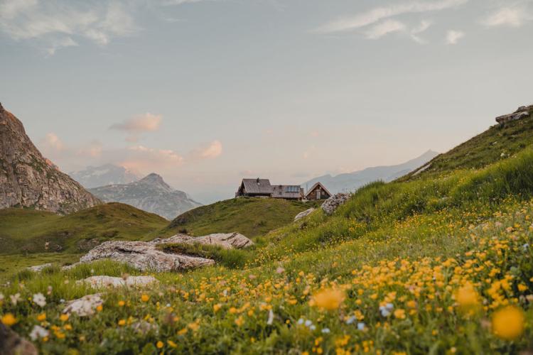 Le refuge du Fond des Fours vue de loin avec les fleurs en été - Le refuge du Fond des Fours vue de loin avec les fleurs en été